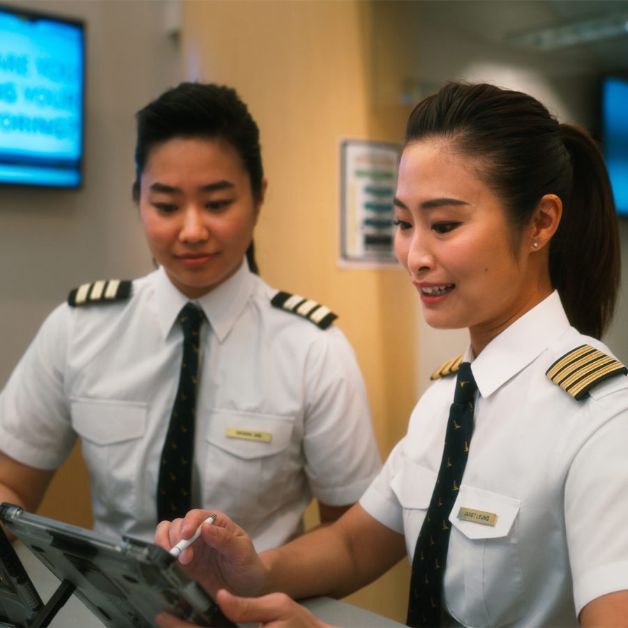 Two flight crew sign off their training progress on a tablet.